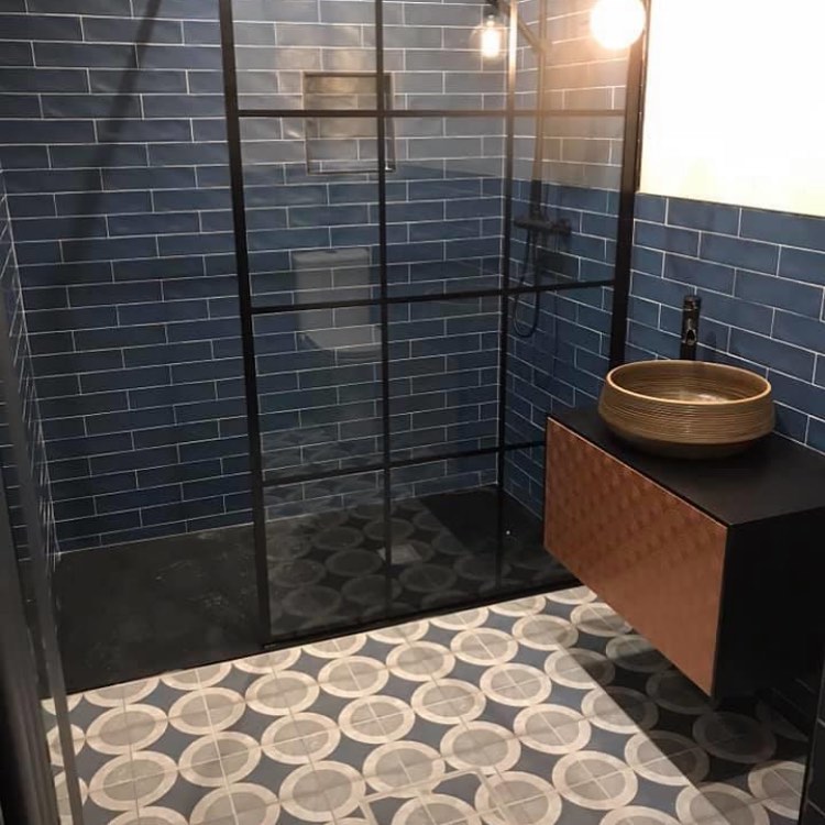 Bathroom with black-framed shower, blue wall tiles and patterned floor