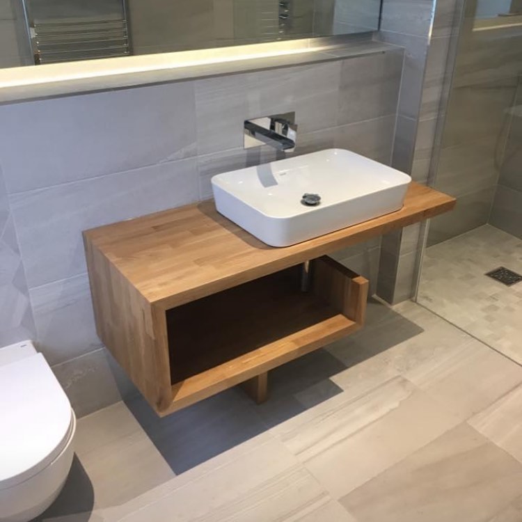 Timber vanity with countertop basin beside a glass walk-in shower