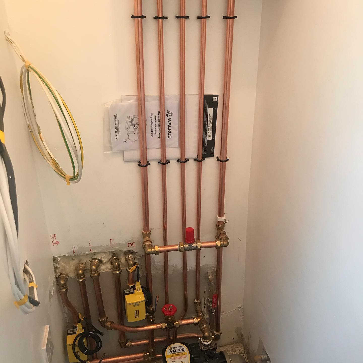 Copper heating pipework and brass valves in a plant cupboard
