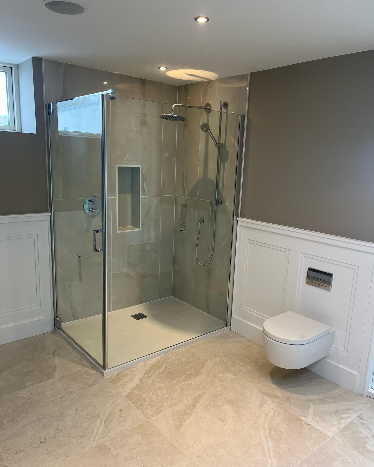 Walk-in shower with wainscot panelling and wall-hung WC